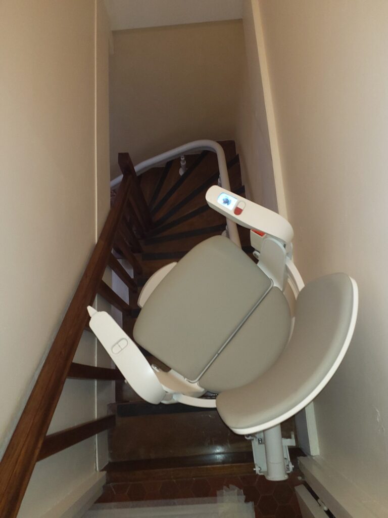 Nouvelle installation d'un monte escalier Otolift Modul-Air Smart sur un escalier courbe de 73cm de large avec une porte en haut, à La Bachellerie (24) . Pour plus de confort pour nos clients, nous avons réglé le fauteuil de biais.