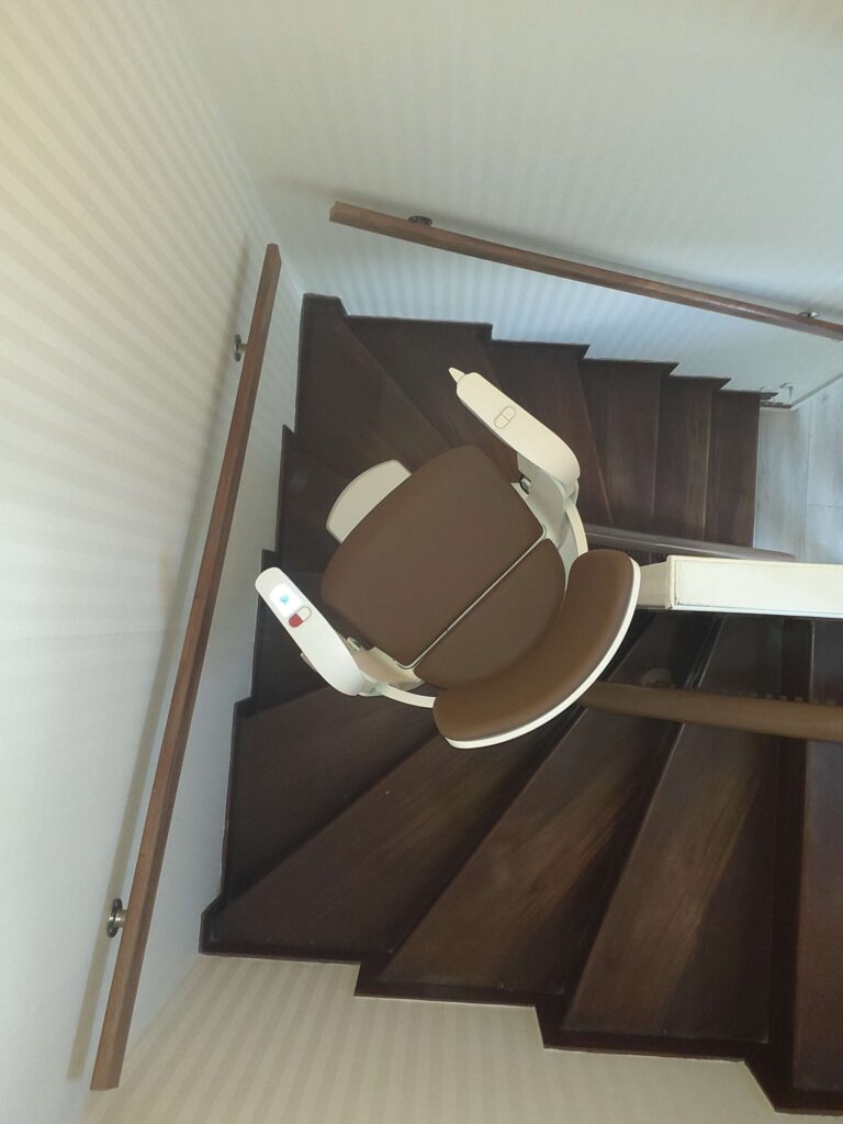 Monte-escalier courbe Otolift Modul'Air mur sur un escalier en bois 2/4 tournant à Limoges