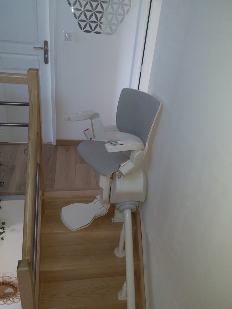 Monte-escalier Otolift Modul'Air côté rambarde sur un escalier en bois 1/4 tournant à St Cyr la Roche