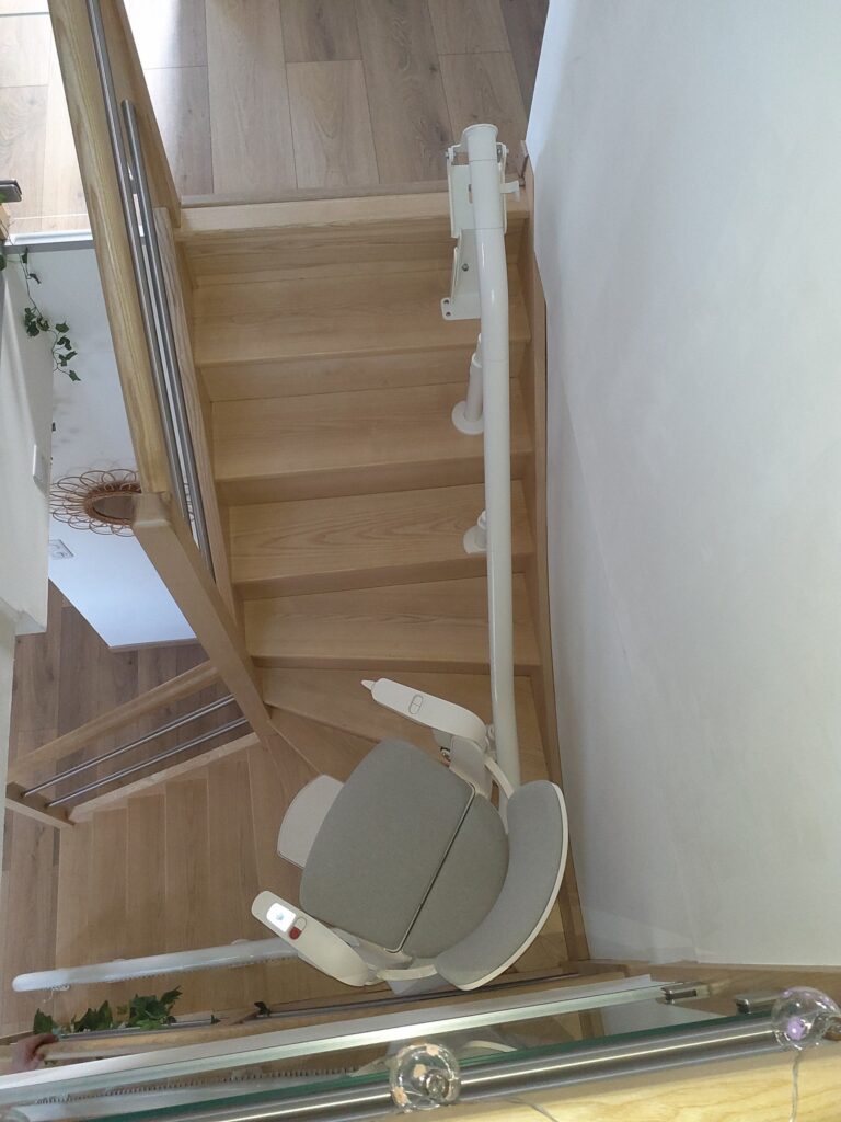 Monte-escalier Otolift Modul'Air côté rambarde sur un escalier en bois 1/4 tournant à St Cyr la Roche