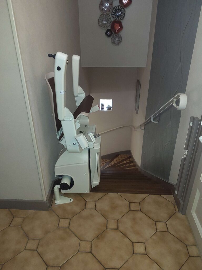 Installation d'un monte-escalier courbe Handicare avec un siège Alliance à Brive.