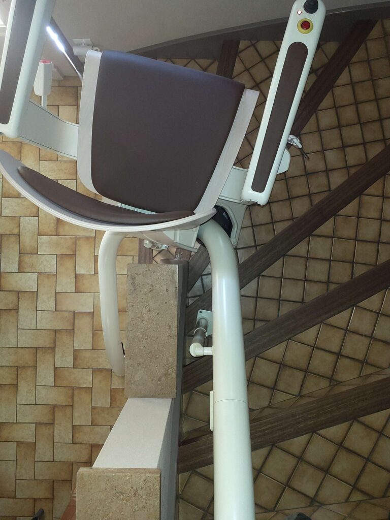 Installation d'un monte-escalier courbe Handicare avec un siège Alliance à Brive.