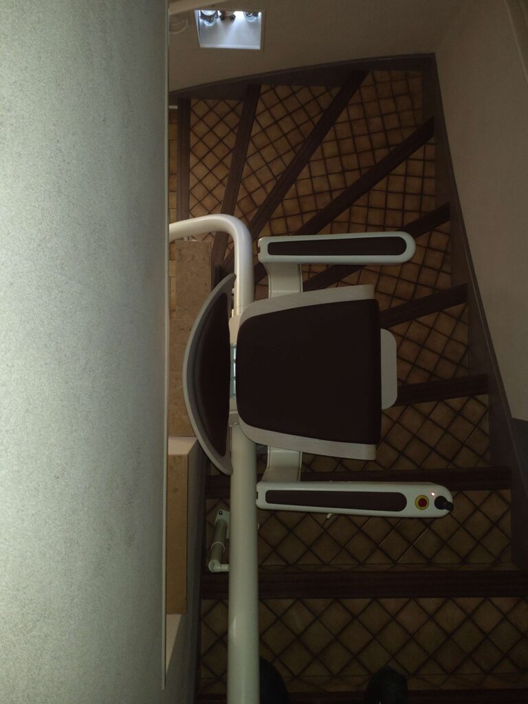 Installation d'un monte-escalier courbe Handicare avec un siège Alliance à Brive.