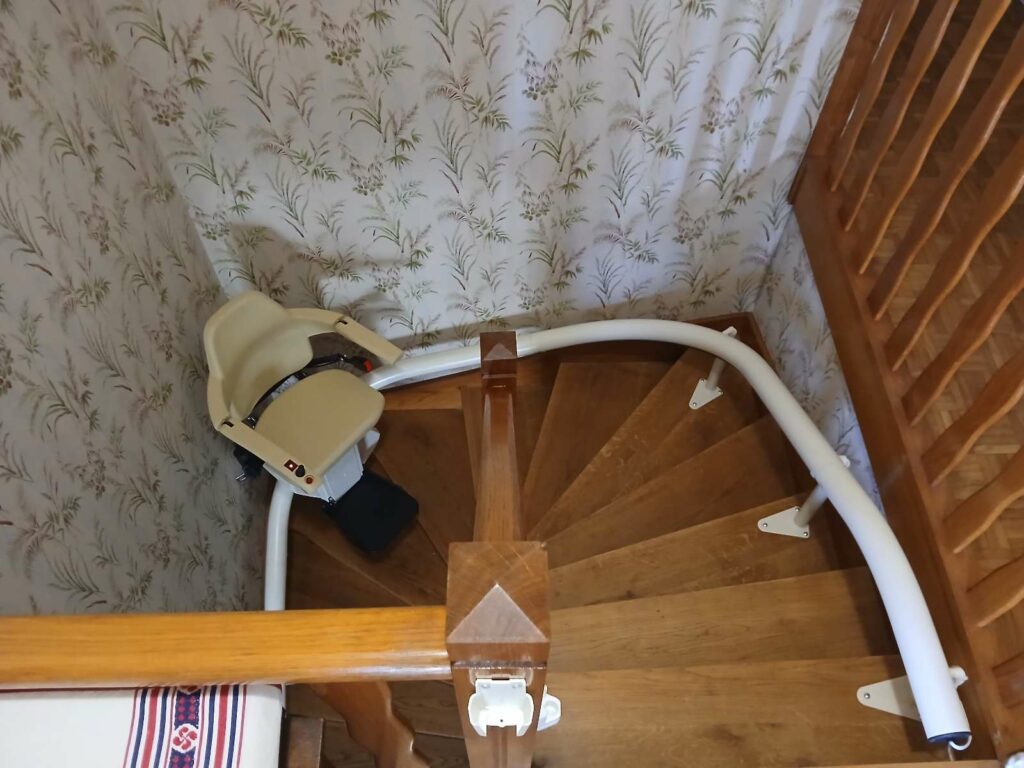 Nouvelle installation d’un monte-escalier courbe Handicare avec un siège Classic sur un escalier en bois 2/4 tournants à Brive (19) – photo 3/5